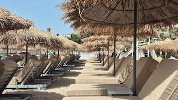 Praia particular, espreguiçadeiras, guarda-sóis