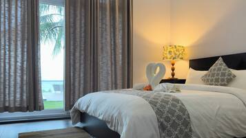 Una habitación de hotel con cama, mesita de noche, lámpara y vistas al exterior.