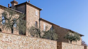 A stone building with a swimming pool in front.