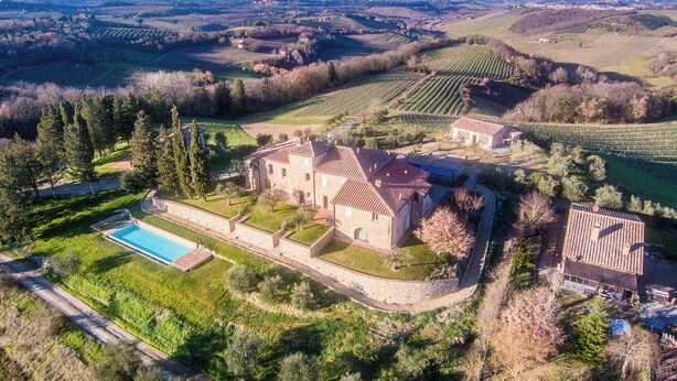 A large estate with a swimming pool, multiple buildings, and expansive fields.