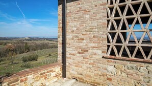 A brick building with a window featuring a geometric pattern.