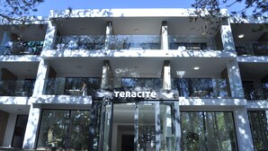 Un hotel de varios pisos con un diseño moderno, con amplios ventanales y balcones.