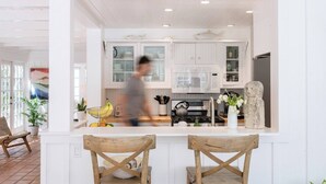 Una cocina moderna con armarios blancos, una isla central y una escultura de piedra.