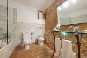 A bathroom with a glass-enclosed shower, two toilets, a glass sink with a mirror, and a towel rack. - Agritourism SA Franquesa Vella (Vilafranca de Bonany)
