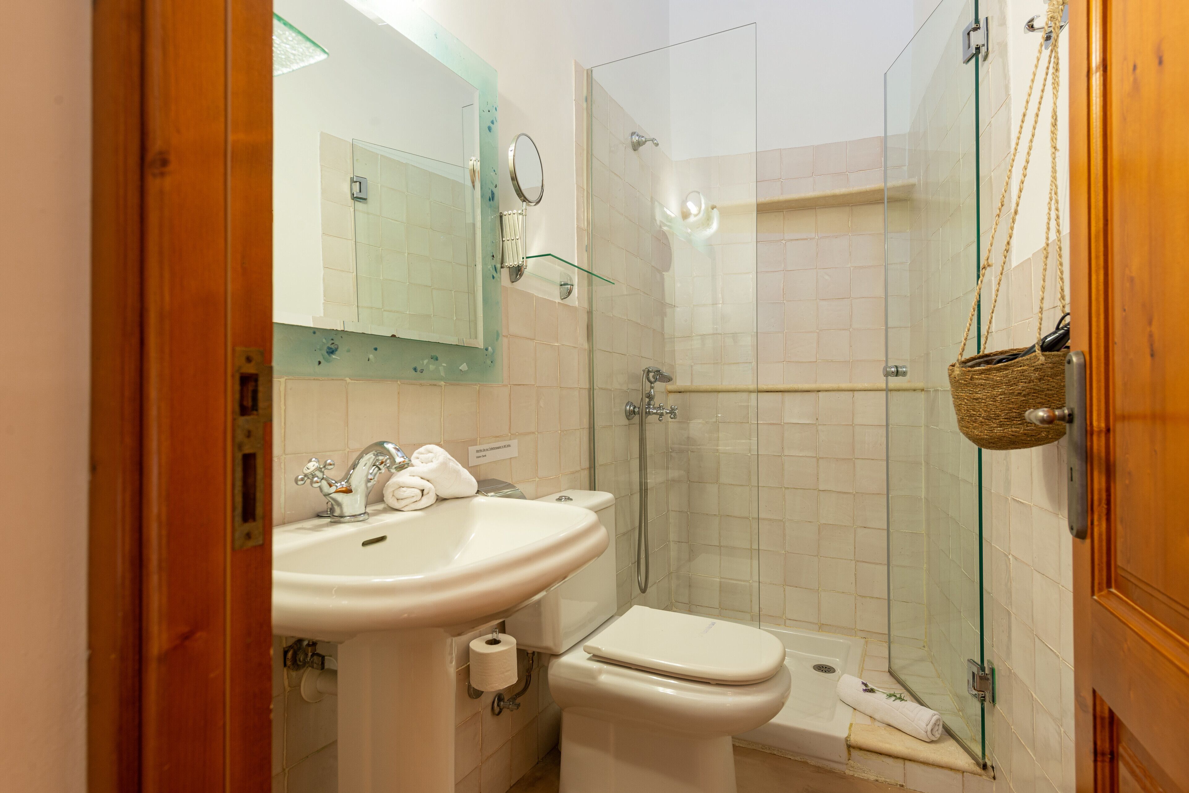 A bathroom with a sink, toilet, and glass-enclosed shower.