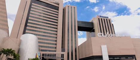 Un edificio moderno con varios rótulos comerciales, incluyendo 'Banesco' y 'CLX Group'.