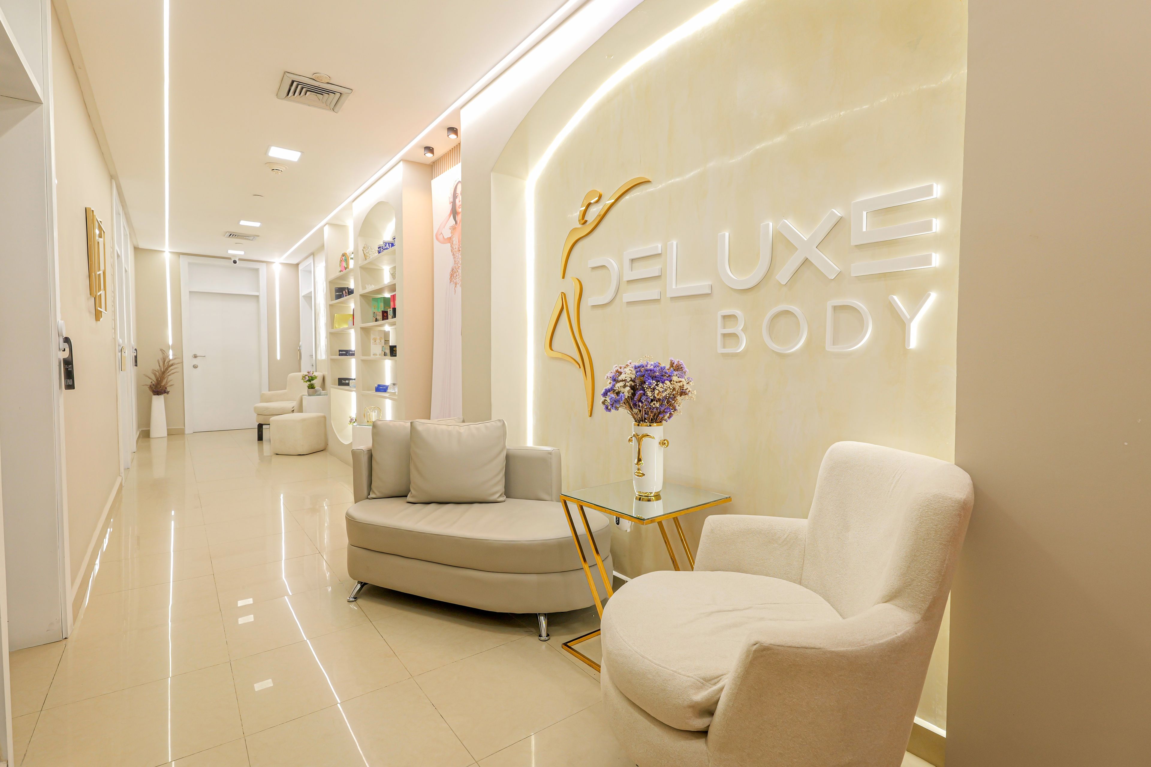 A modern interior with a reception desk, a sofa, and a chair in a well-lit hallway.