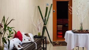 A hotel room with a wooden bench, a small table with a white tablecloth, and a door leading to a red-lit hallway. - Hotel Hesperia de Valencia (Naguanagua)