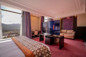 A hotel room with a large bed, a TV, a sofa, and a desk. - Hotel Hesperia de Valencia (Naguanagua)