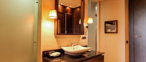 A modern bathroom with a large mirror, a sink, and two wall-mounted lights.