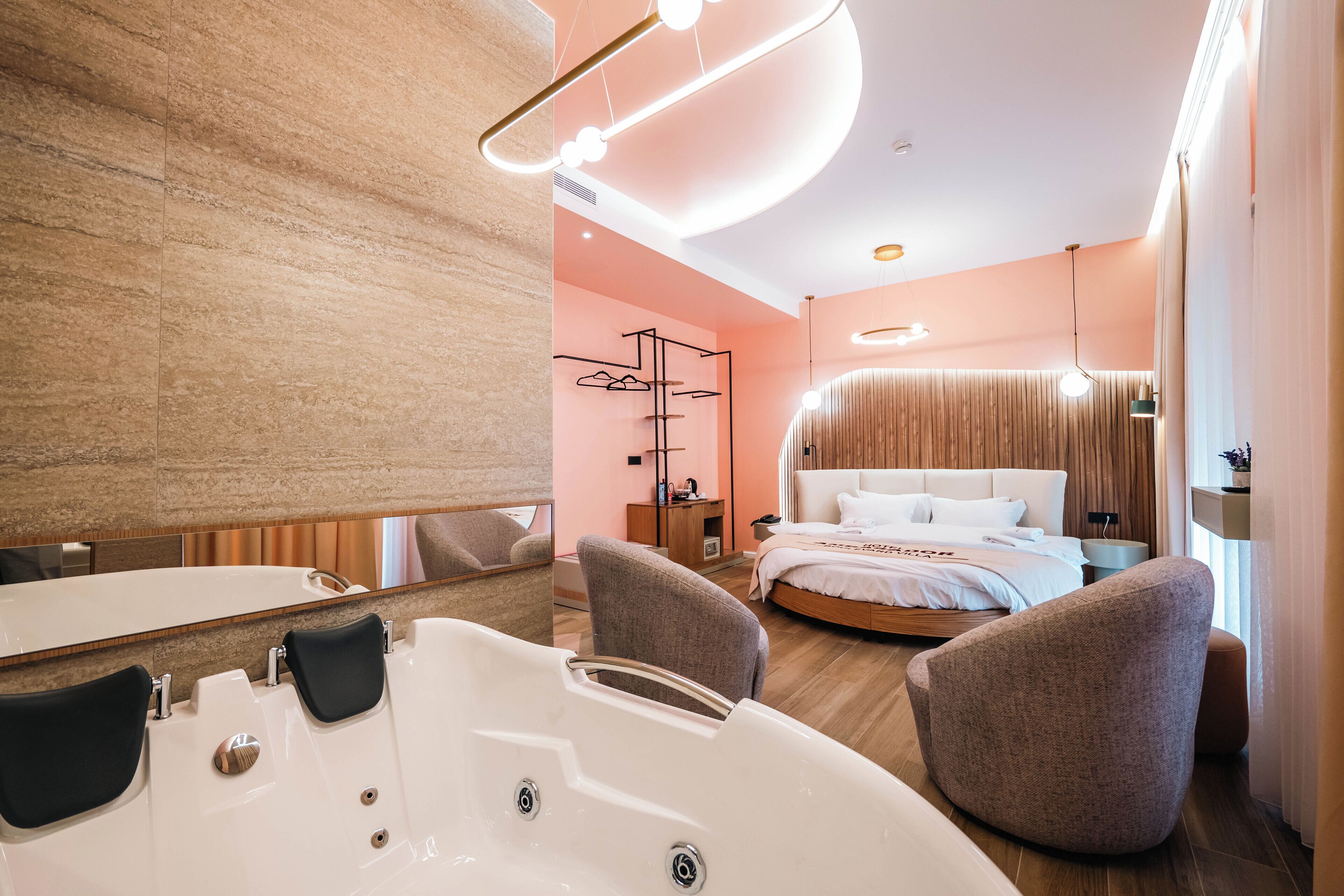 A modern bathroom with a large bathtub, two sinks, and a mirror.