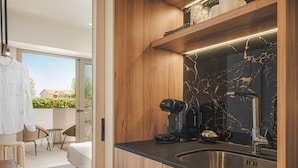 A modern kitchen with a black marble backsplash, wooden cabinets, and a stainless steel sink. - Palm Tree Beach Suites (Zakynthos)