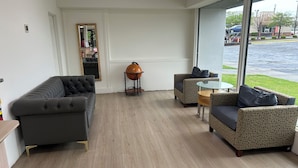 A modern living room with a grey sofa, patterned armchairs, a glass coffee table, and a globe on a stand. - 1st Place at Wesley (Decatur)