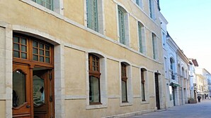 A historic building with a large wooden door and multiple windows. - Chambre d'Art (Dax)