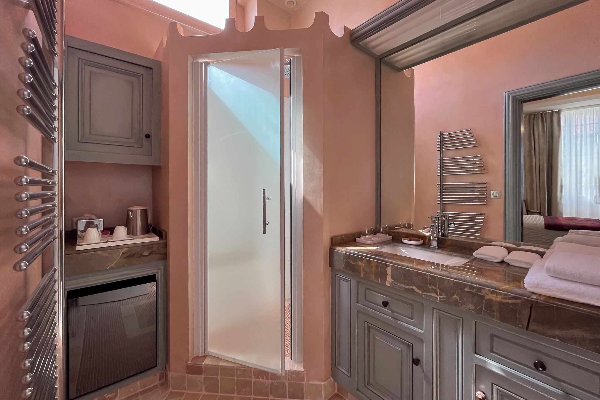 Une salle de bain avec une douche, un meuble-lavabo et un porte-serviettes.