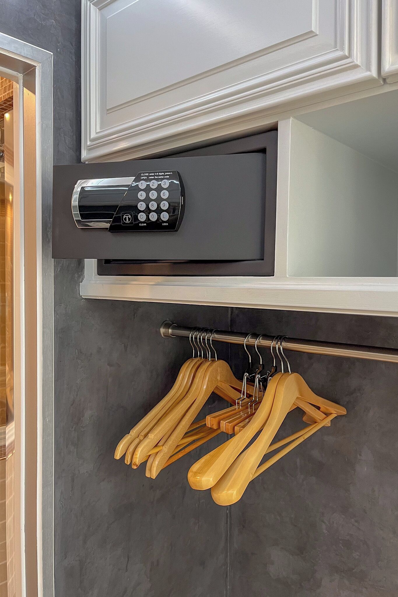 A modern kitchen with a built-in microwave and a wooden spoon rack.