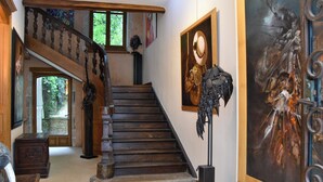 A grand staircase with wooden railings and a statue at the top. - Chambre d'Art (Dax)