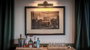 A framed historical photograph above a bar area with bottles and glasses.