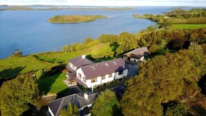 A large house with a spacious front yard and a view of a lake.