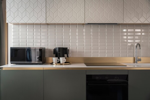 A modern kitchen with a microwave, coffee maker, and sink. - Palazzo Dei Guardiani (Venice)