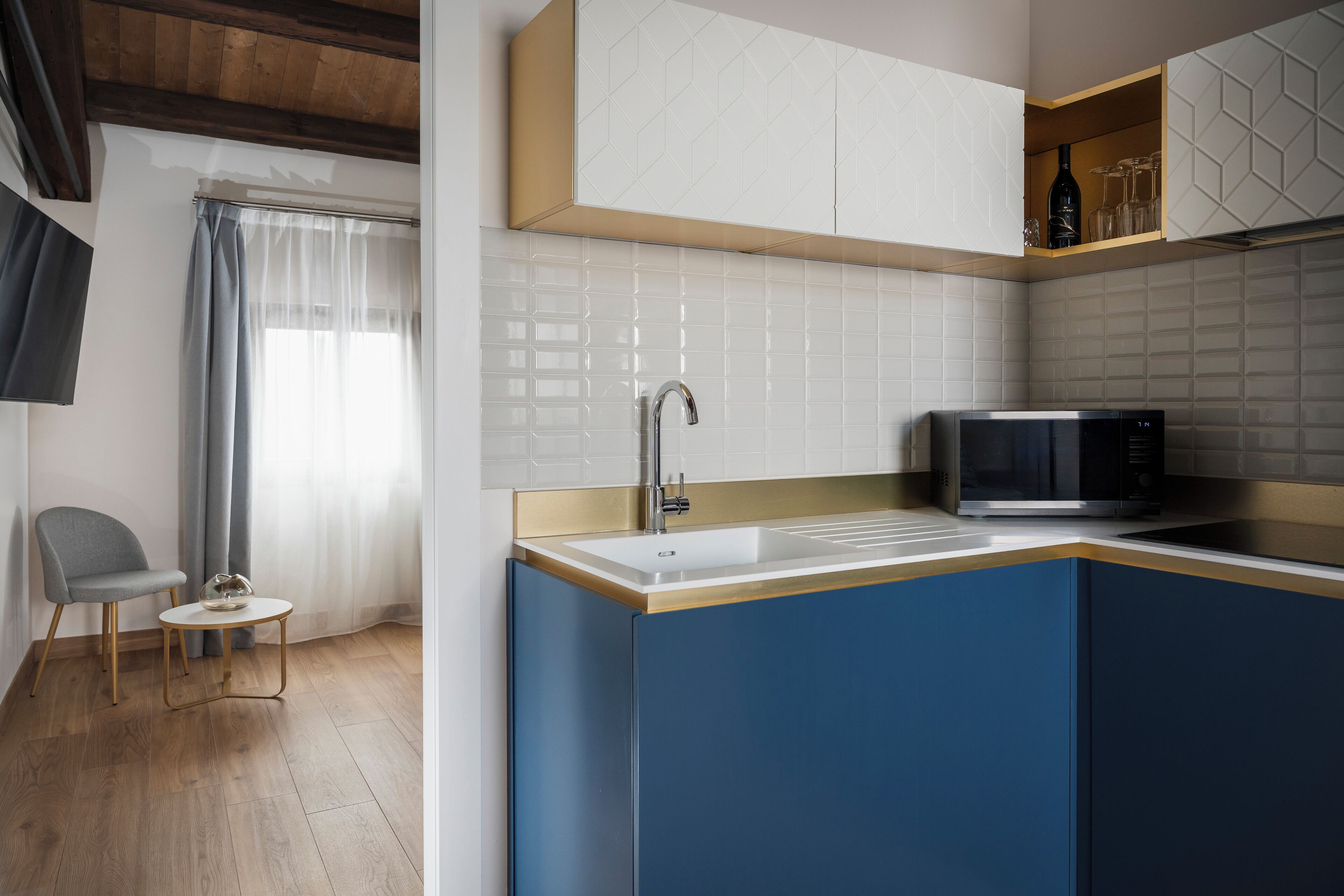 Una cocina moderna con microondas integrado, un lavamanos y una pequeña mesa redonda.