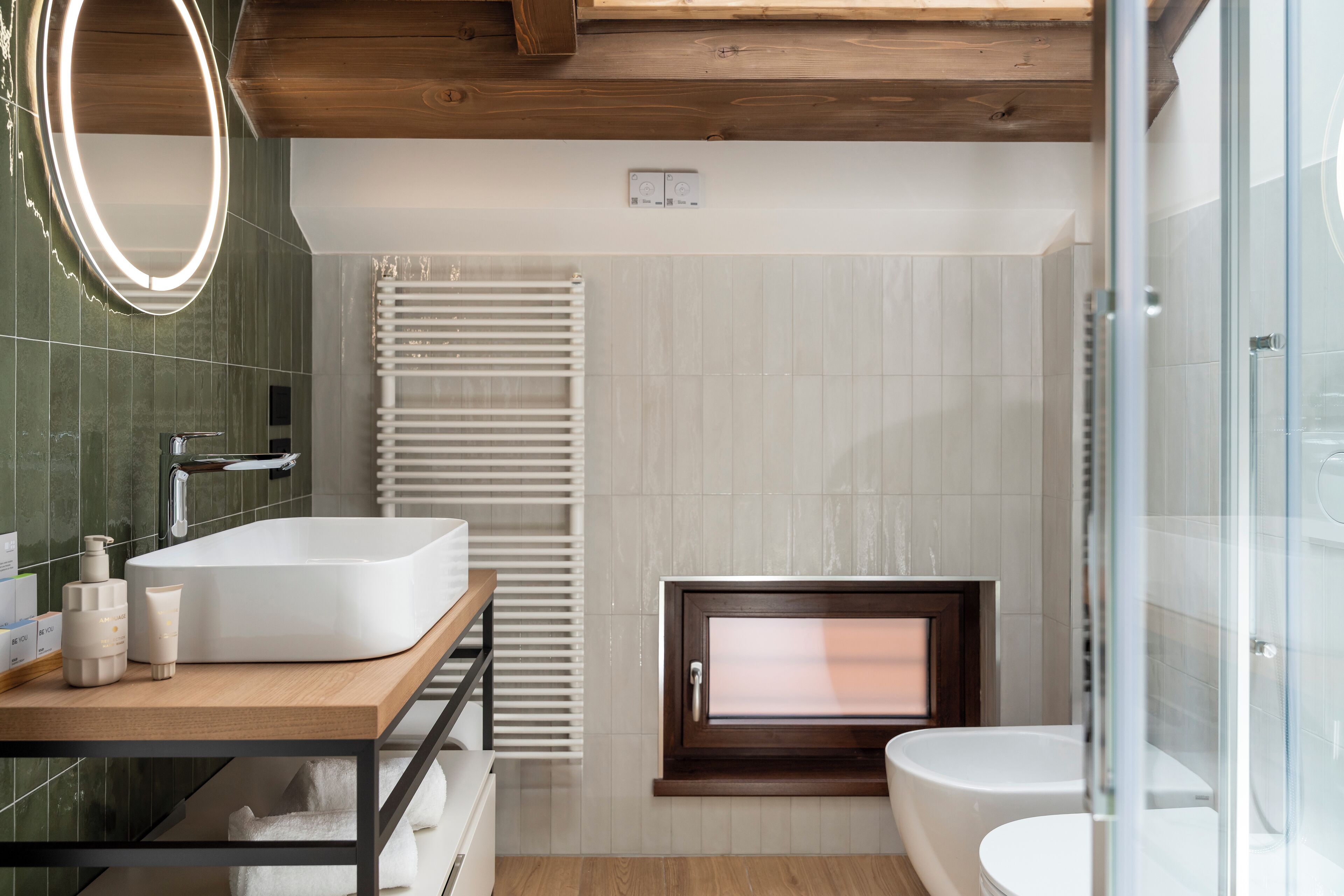 A modern bathroom with a freestanding sink, a built-in window, and a glass shower enclosure.