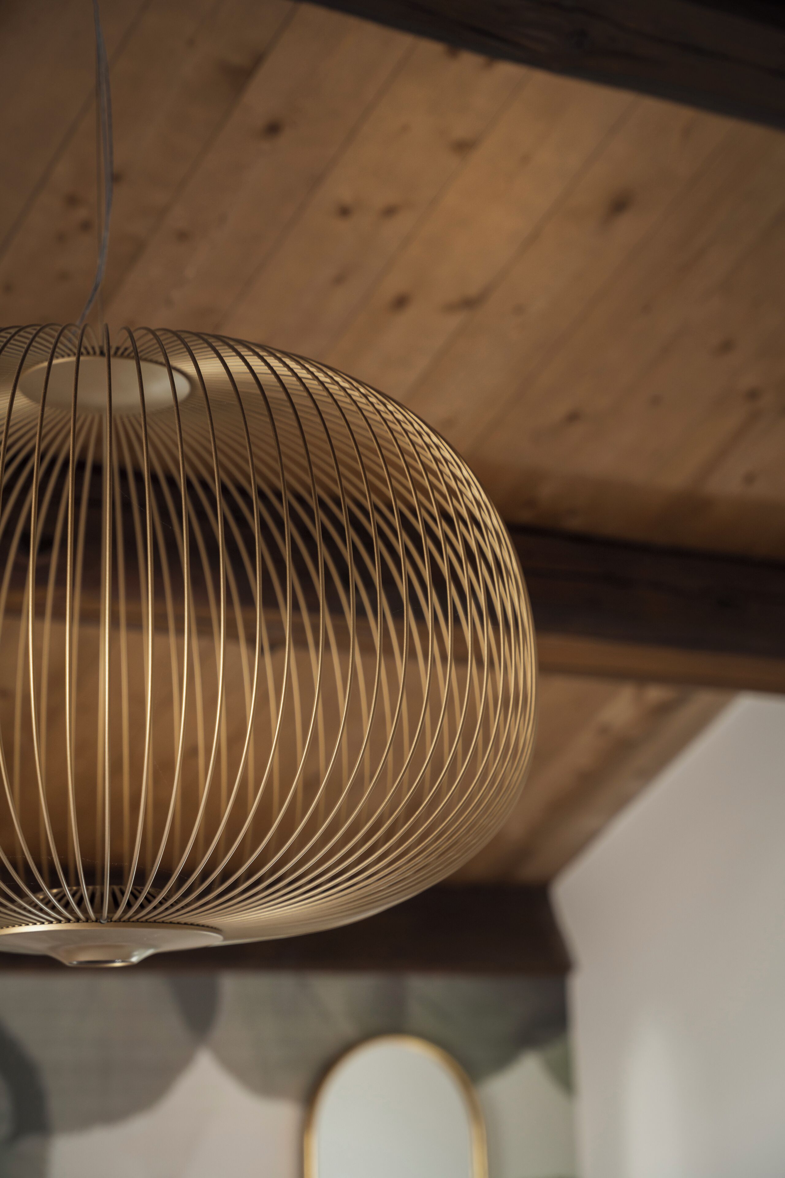 Una lámpara colgante con diseño acanalado, suspendida del techo de madera.