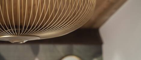 Un luminaire suspendu, de type suspension, avec un design à motifs en relief, fixé à un plafond en bois.