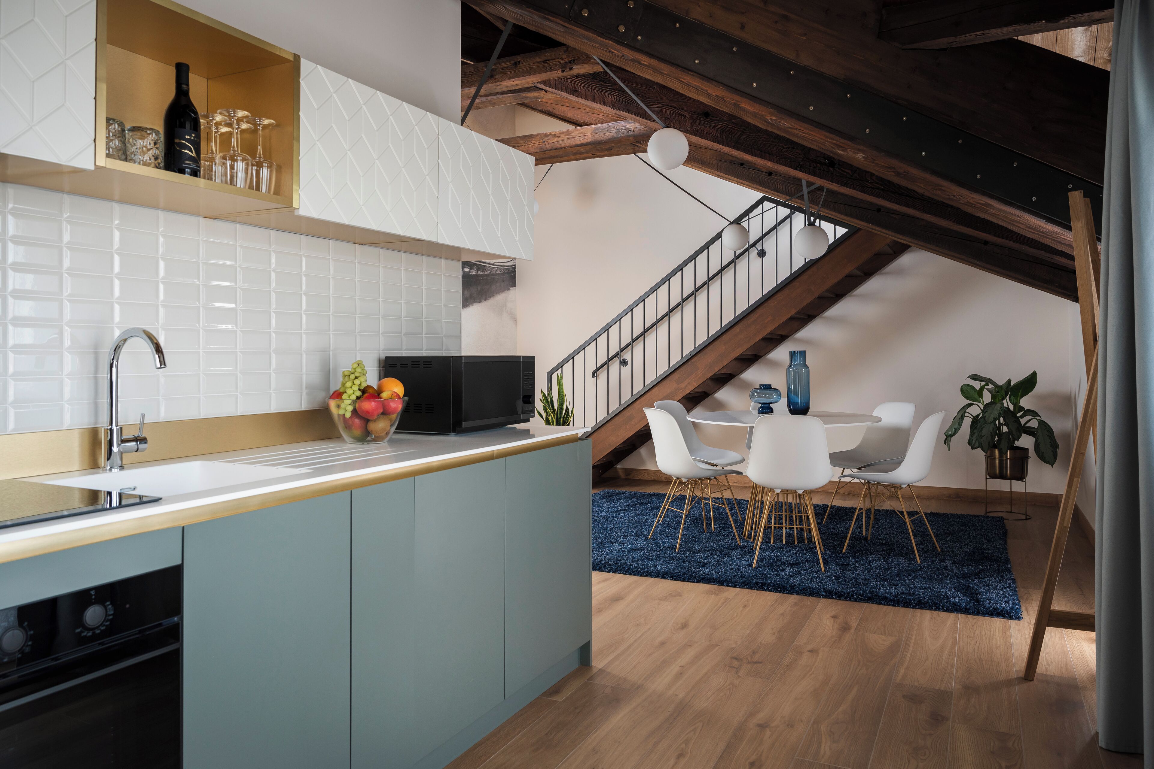 A modern kitchen with a built-in island, white tiles, and a wooden ceiling.