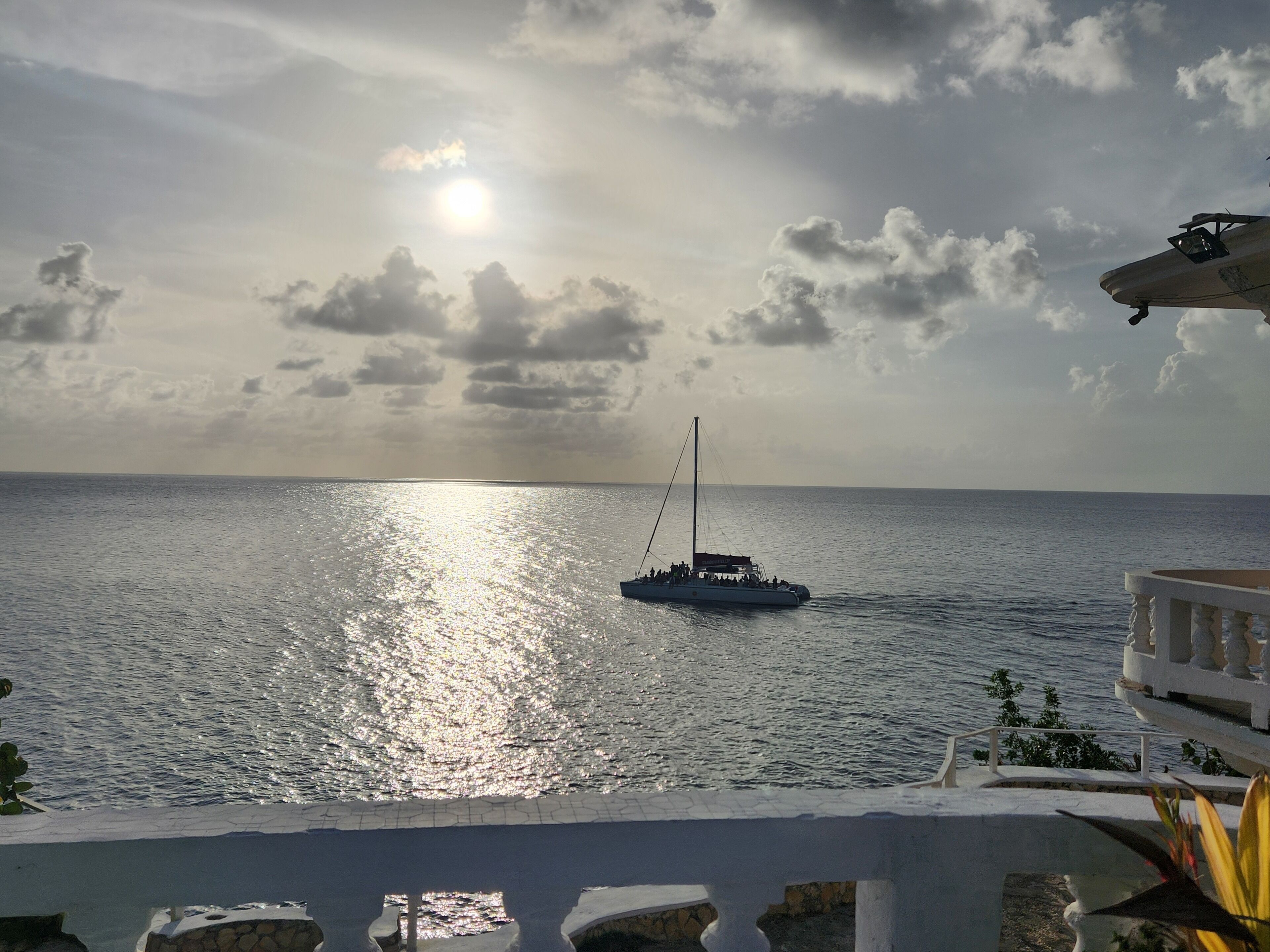 Un barco sobre aguas tranquilas, cielo despejado y reflejo del sol.