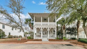 A two-story building with a white exterior, a balcony on the upper floor, and a front porch. - Cypress by the Sea (Santa Rosa Beach)