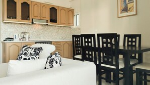 A modern kitchen with wooden cabinets and a dining area with black chairs.