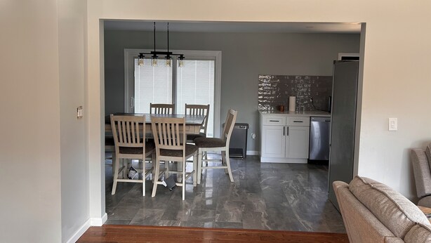 A modern kitchen with a refrigerator, microwave, and a tiled backsplash. - Newly Renovated 4-Bedroom Saugerties Home 10 minutes from HITS with AC and Wi-Fi (Saugerties)