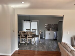 A modern kitchen with a refrigerator, microwave, and a tiled backsplash.