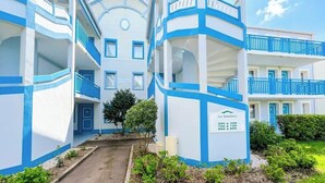 A multi-story hotel with blue and white exterior walls, balconies, and a sign indicating 'Les Santolines.'