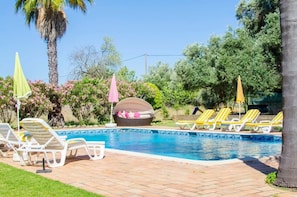 A swimming pool with lounge chairs and umbrellas, surrounded by greenery and palm trees. - Idyllic Farm House Amazing Landscap Sea View (Loulé)