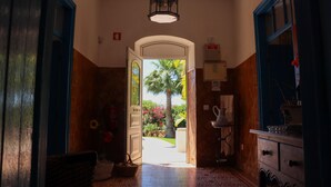 A hallway with a door leading to a garden.