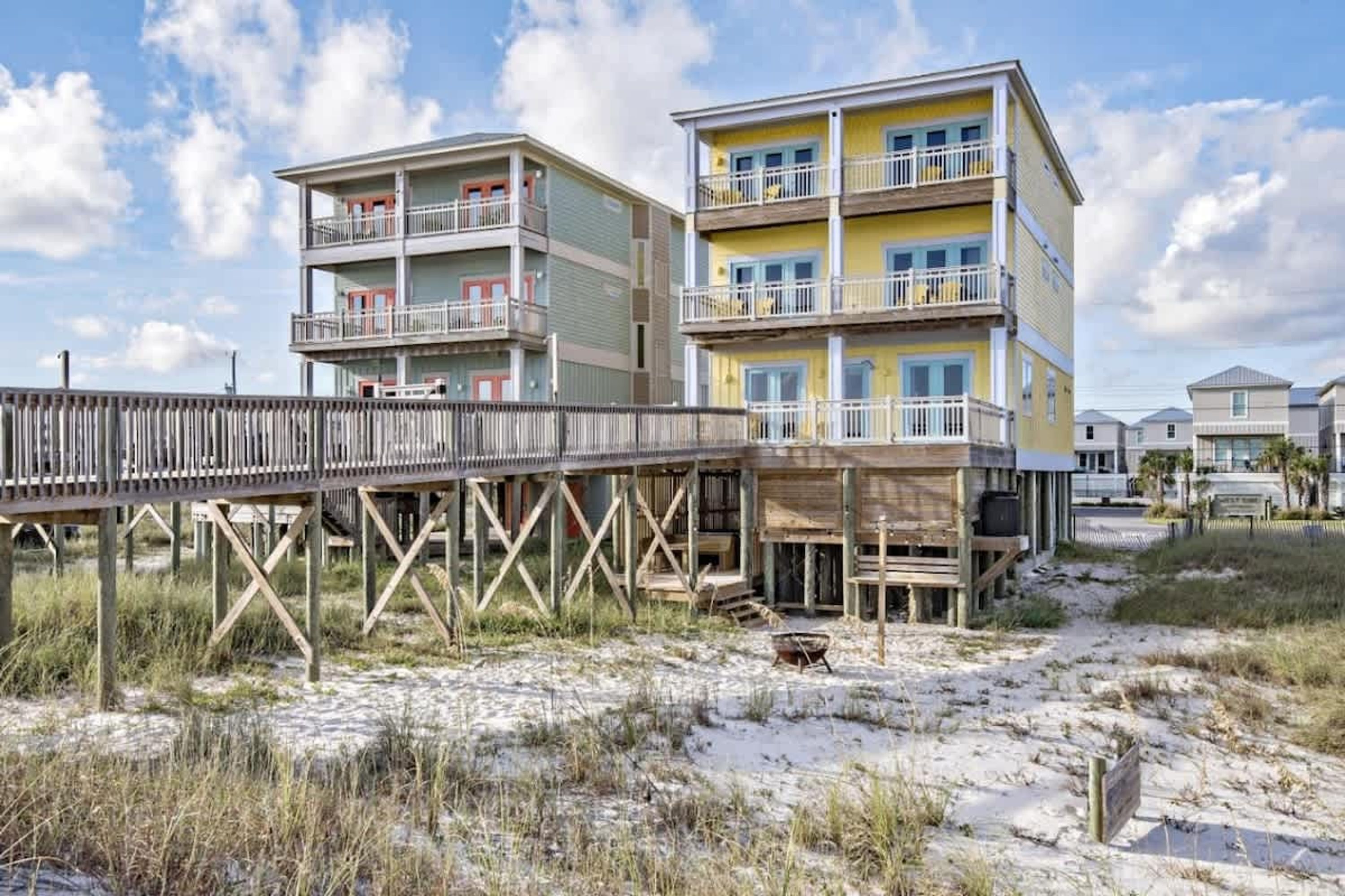Een gebouw aan het strand met meerdere balkons en een houten terras.