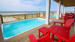 A wooden deck with a pool and red chairs overlooking the ocean. - Beachfront 18bed Pool Easybreezy (Gulf Shores)