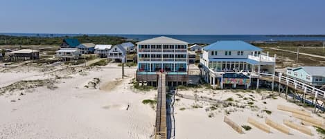 A beachside hotel with multiple buildings, a pier, and a sandy beach.