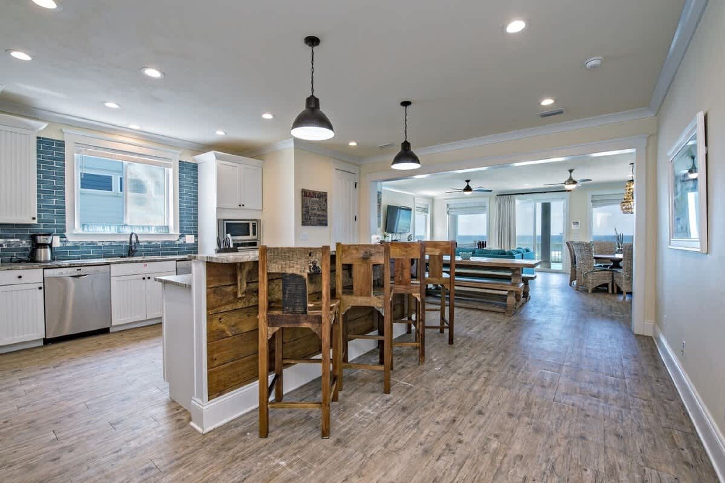 A spacious kitchen with wooden chairs, a dining area with a view, and a modern design.
