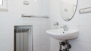 A modern bathroom with a white sink, a mirror, and a towel rack. - Studio House da Pasolini a Mastroianni (Rome)