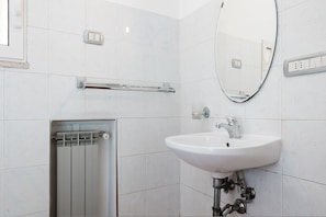A modern bathroom with a white sink, a mirror, and a towel rack. - Studio House da Pasolini a Mastroianni (Rome)