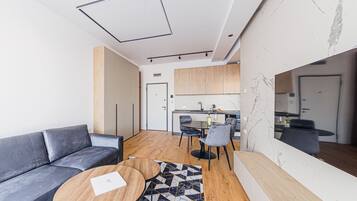 A modern living room with a grey sofa, a wooden coffee table, and a patterned rug.
