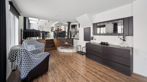 A modern living room with a fireplace, a sofa, a dining area, and a large mirror. - Escape to Grandes-Piles (Grandes-Piles)