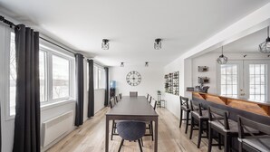 A dining area with a long table, chairs, and a bar counter. - Escape to Grandes-Piles (Grandes-Piles)