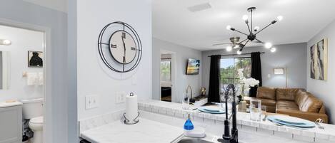 A modern kitchen with a built-in dishwasher, a sink with a faucet, and a ceiling light fixture.