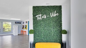 Une pièce avec un mur vert, un banc jaune et une enseigne sur laquelle on peut lire : « Fitus – Ambiance ».