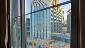 A modern hotel interior with large windows offering views of a cityscape, including a distinctive building with a unique architectural design. - VITA Hotel (St. Julian's)