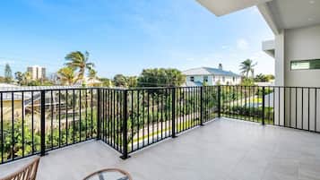 Een balkon met uitzicht op een woonwijk, met huizen en palmbomen.